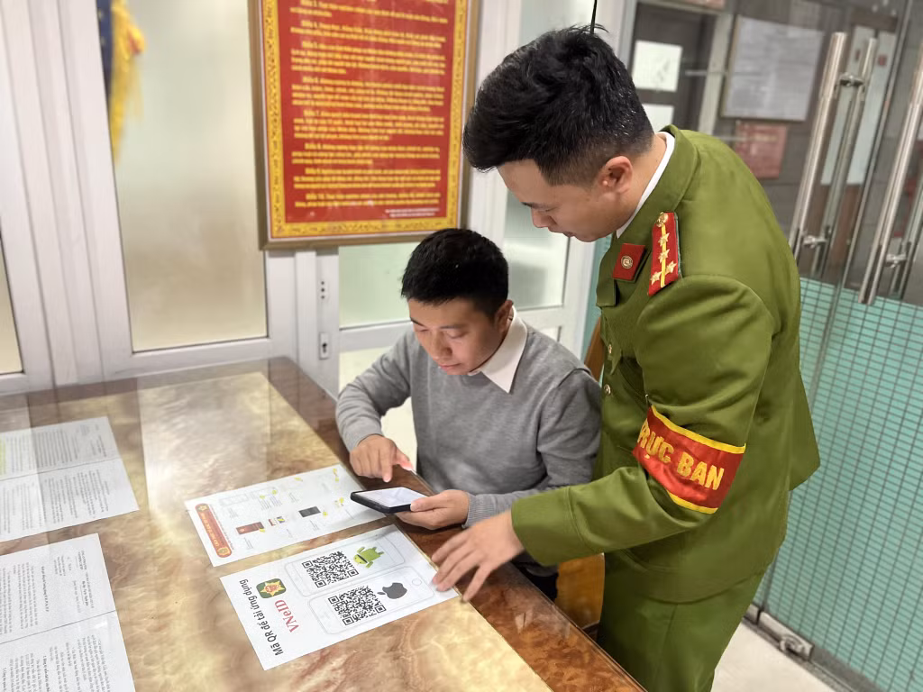 Trực ban hình sự Công an tỉnh hướng dẫn công dân sử dụng tính năng tố giác tội phạm qua ứng dụng VNeID. Ảnh: Ngọc Khôi