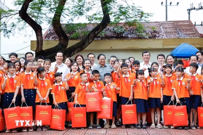 Thủ tướng Phạm Minh Chính tặng quà cho trẻ em tại Trung tâm Nuôi dưỡng trẻ khuyết tật Hà Nội. (Ảnh: Dương Giang/TTXVN)