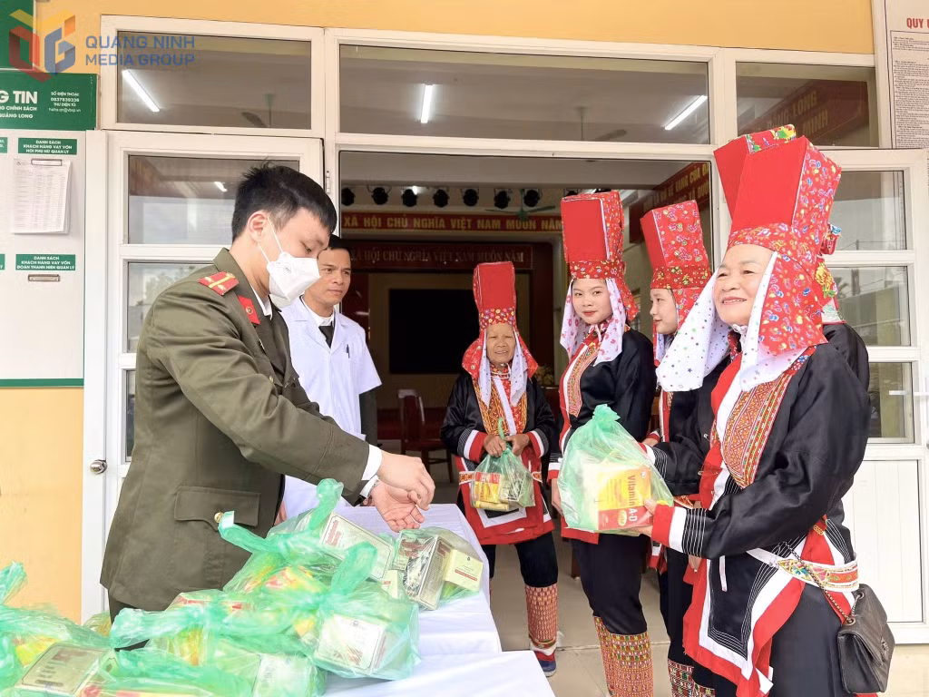 Cán bộ y tế và chiến sĩ công an phát thuốc miễn phí cho bà con người Dao Thanh Phán.