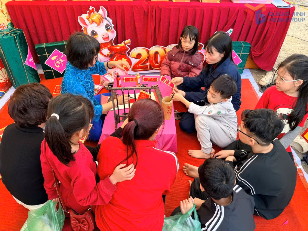 Nhiều phụ huynh, học sinh và người dân trải nghiệm tại gian hàng viết thư pháp tại chợ hoa Xuân phường Hà Lầm.