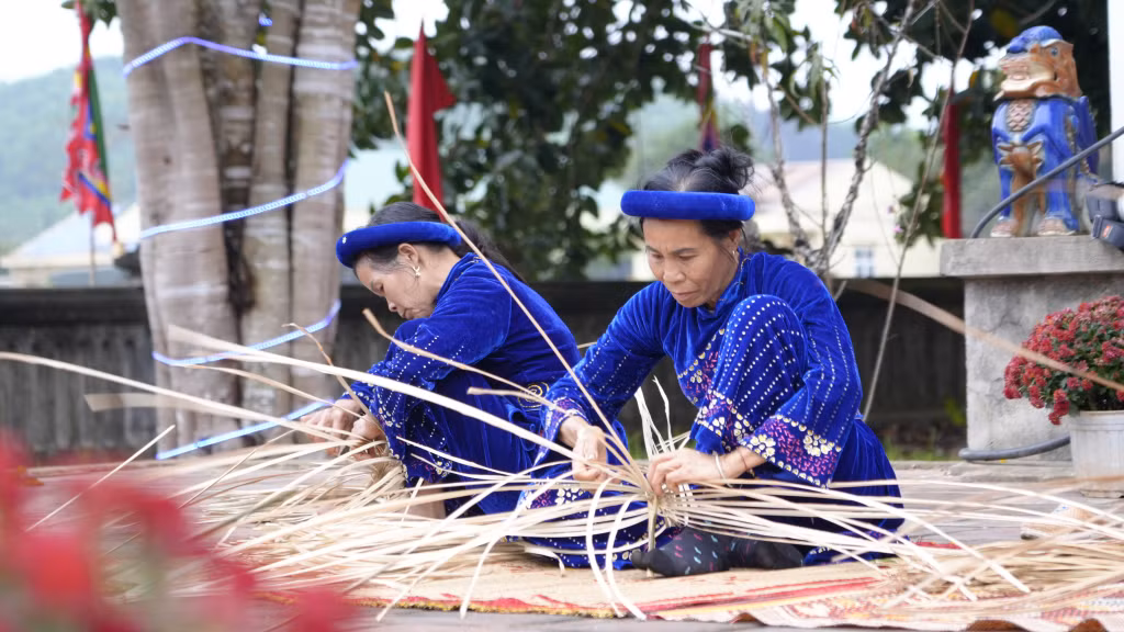 Các nghệ nhân trình diễn đan quạt cọ truyền thống.