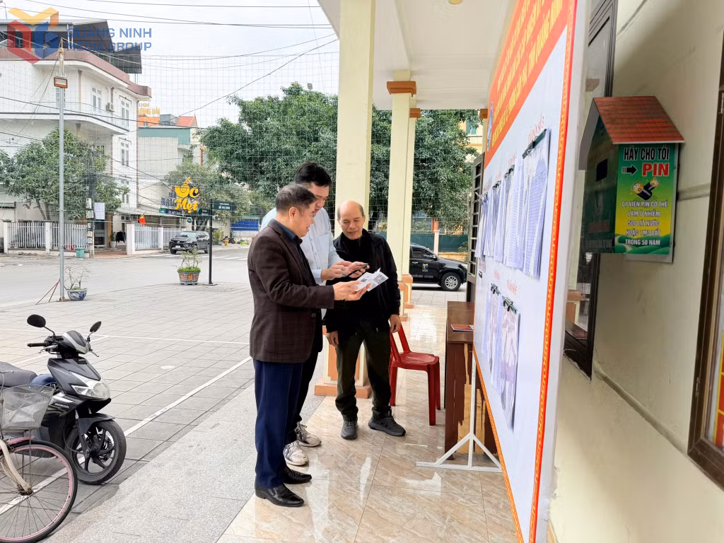 Người dân phường Cẩm Phả quét mã QR trên điện thoại để tìm hiểu thông tin bầu cử trong Cẩm nang phục vụ công tác tổ chức bầu cử do phường biên soạn.