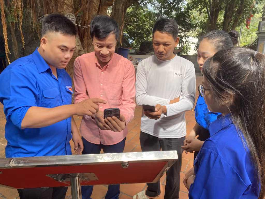 ĐVTN thị trấn Cái Rồng (huyện Vân Đồn) hướng dẫn người dân quét QR Code tại Đền thờ vua Lý Anh Tông.