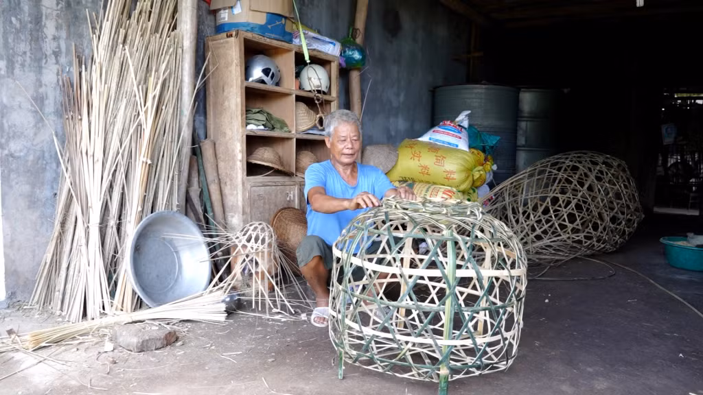 Ngoài đan mũ lá tre, ông Minh còn đan các sản phẩm lồng gà, quang gánh, mẹt...