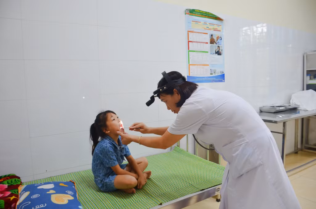 Bác sĩ Trạm Y tế xã Quảng La (TP Hạ Long) khám bệnh cho trẻ em.