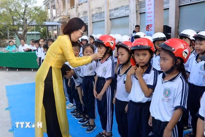 Trao tặng mũ bảo hiểm cho học sinh lớp 1, Trường Tiểu học Nguyễn Hiền, Rạch Giá, Kiên Giang. (Ảnh: Lê Huy Hải/TTXVN)