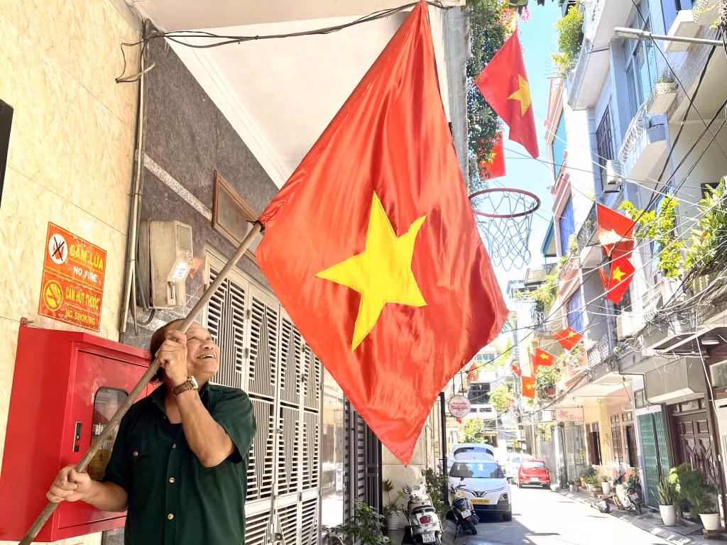Cựu chiến binh Lưu Phương Yên (Tổ trưởng tổ 84, khu 5, phường Bạch Đằng, TP Hạ Long) phấn khởi treo cờ Tổ quốc chào mừng Quốc khánh 2/9.