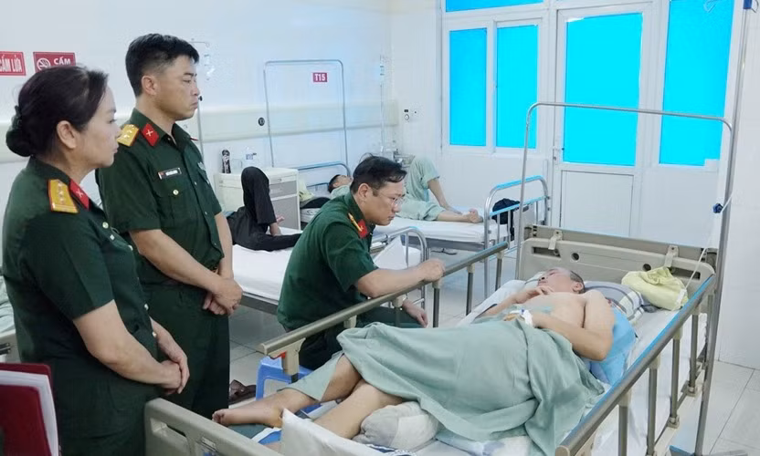 Thượng tá Nguyễn Văn Việt, Phó chính ủy Bộ CHQS tỉnh, trao kinh phí hỗ trợ Trung tá Phạm Thanh Quyết đang điều trị bệnh hiểm nghèo tại Bệnh viện Bãi Cháy. Ảnh: Văn Đảm (CTV)