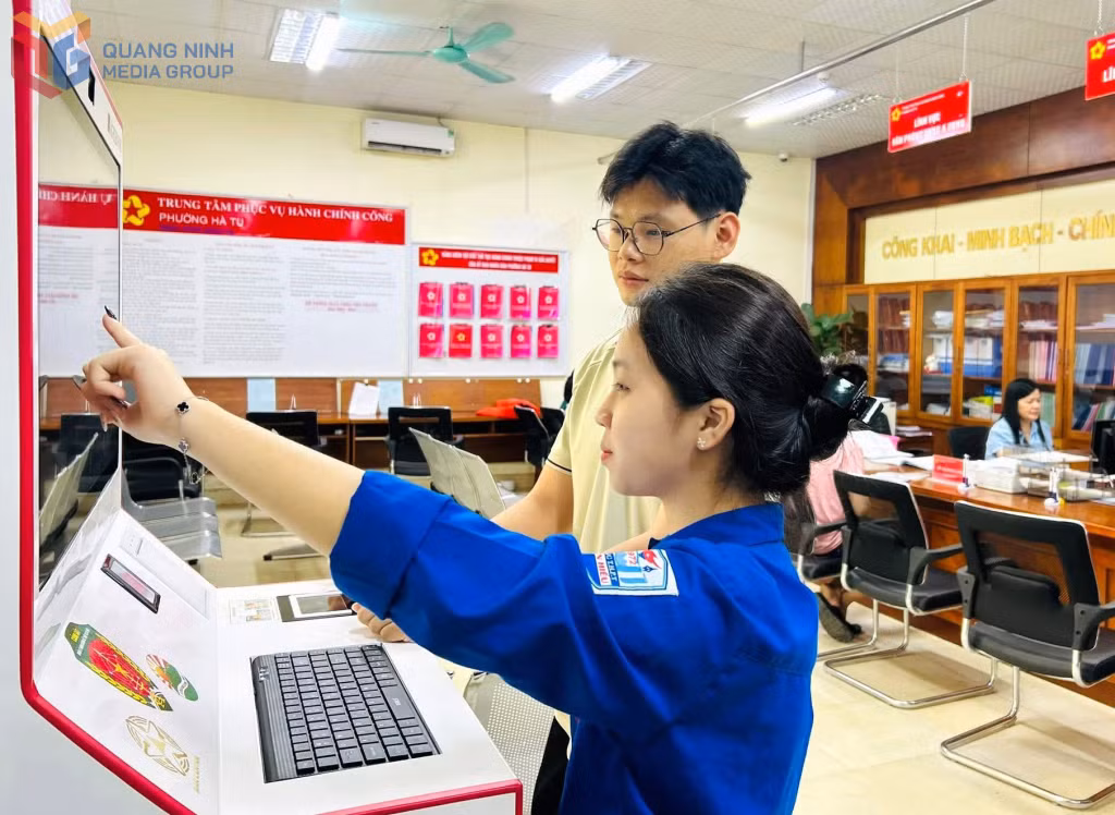 ĐVTN Đội hình thanh niên tình nguyện phường Hà Tu hỗ trợ người dân sử dụng máy Kiosk tại Trung tâm Phục vụ Hành chính công phường.