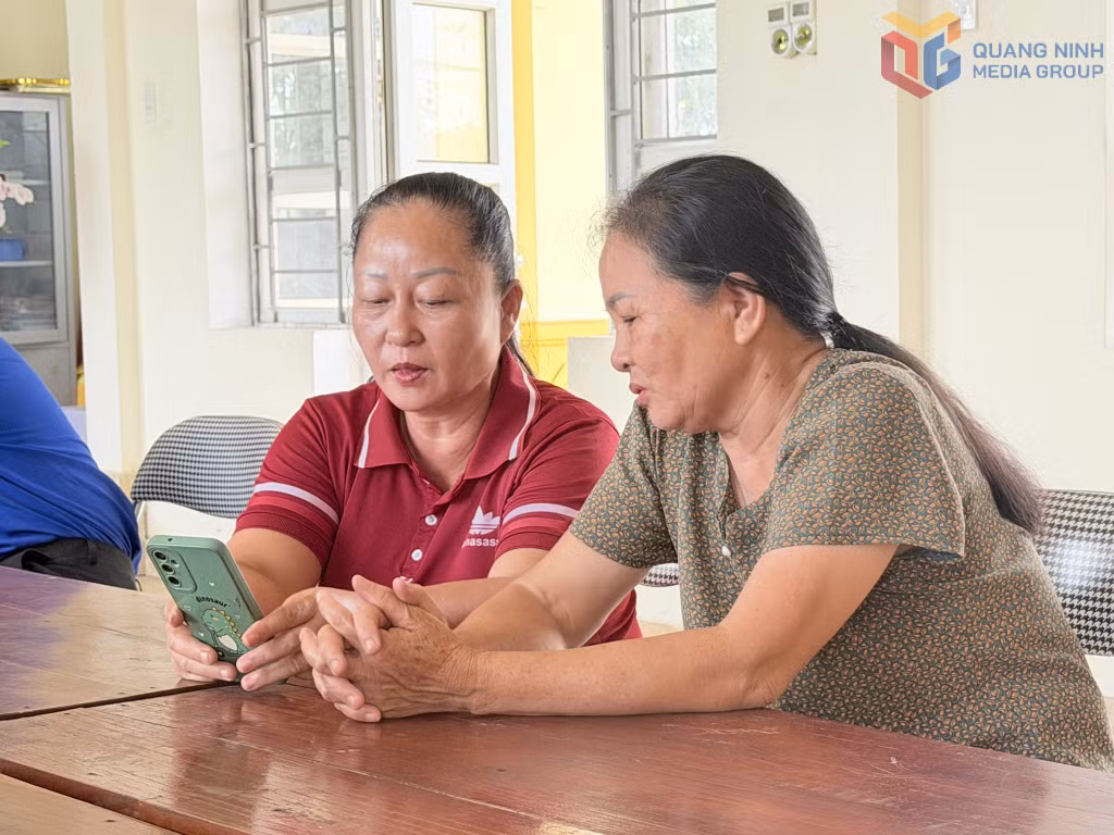 Người dân thôn Xóm Giáo, xã Đầm Hà, sử dụng điện thoại thông minh tra cứu thông tin của thôn.