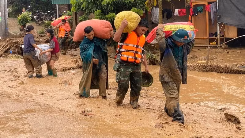Lực lượng cứu hộ di chuyển tài sản giúp người dân vùng lũ đến nơi an toàn.