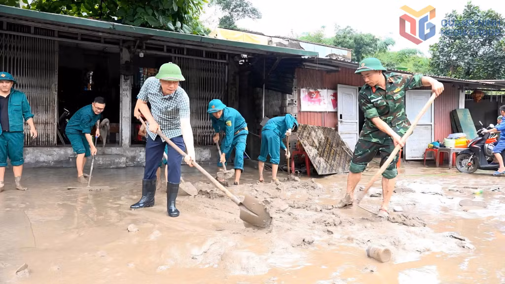 Cán bộ, chiến sĩ Ban CHQS phường Mông Dương giúp người dân khu phố Khe Sím dọn bùn đất sau trận mưa ngày 18 và 19/5.