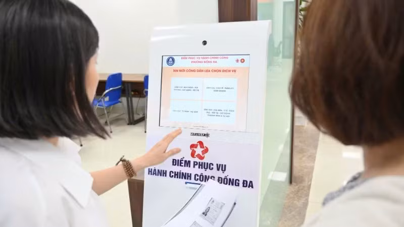 Cán bộ hướng dẫn người dân làm thủ tục hành chính tại Điểm phục vụ hành chính công phường Đống Đa (Thành phố Hà Nội). (Ảnh: THẾ ĐẠI)