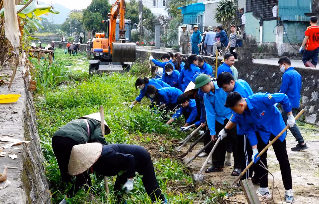 Người dân và lực lượng ĐVTN phường Quang Hanh vệ sinh môi trường, nạo vét kênh mương thoát nước, chủ động ứng phó với mưa bão.