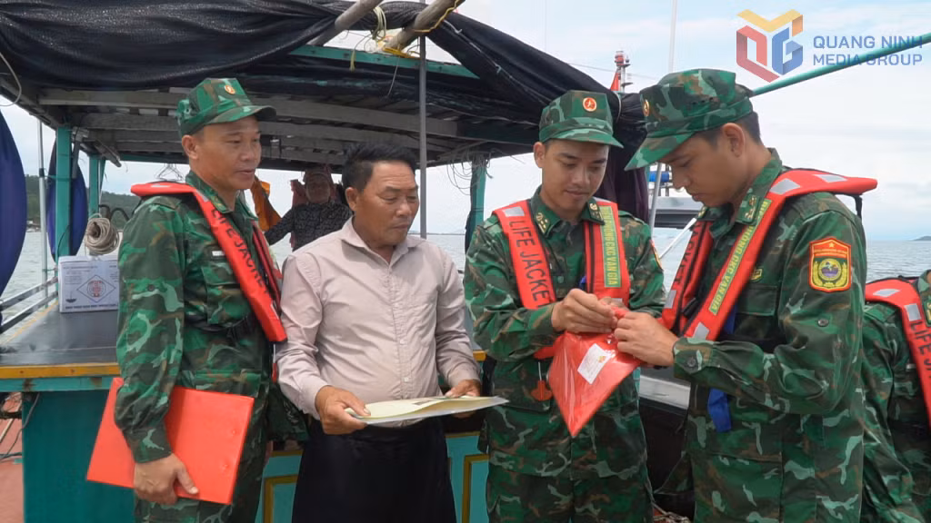 Cán bộ Đồn Biên phòng Cửa khẩu Cảng Vạn Gia tuyên truyền pháp luật và tặng cờ Tổ quốc cho ngư dân trên vùng biển đơn vị quản lý.