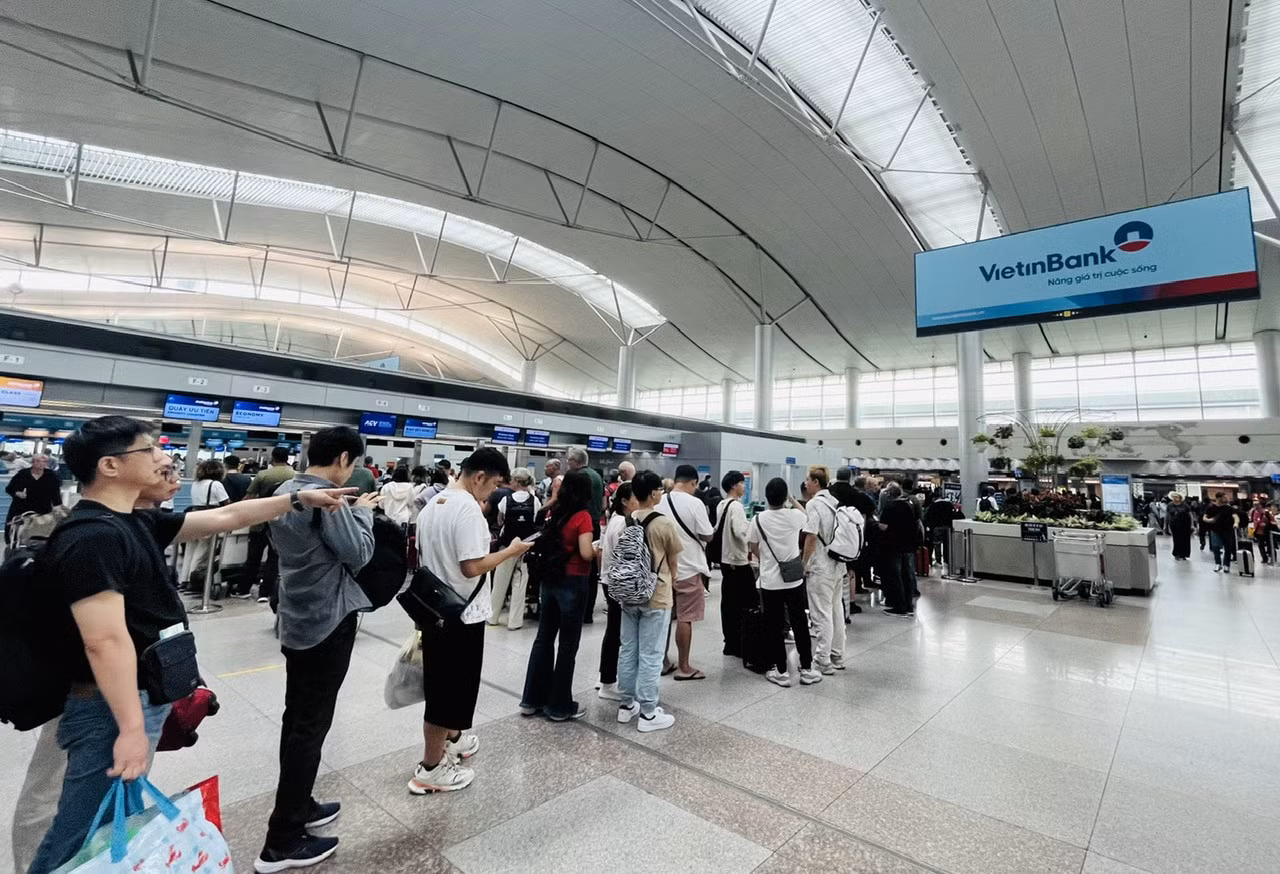 Người dân, du khách xếp hàng chờ làm thủ tục xuất cảnh tại sân bay Tân Sơn Nhất.
