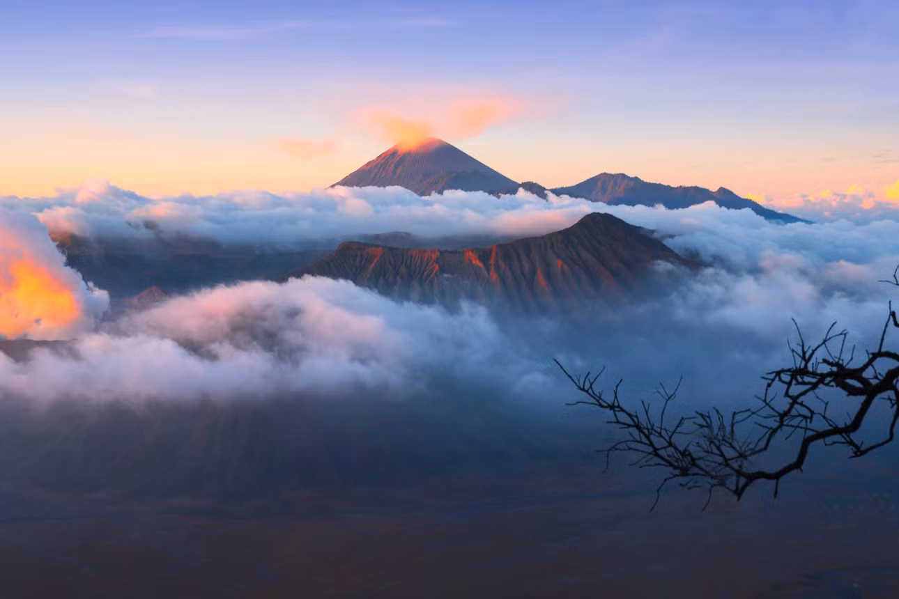 Nhiếp ảnh gia Trần Tiến Dũng, người từng chinh phục Bromo, chia sẻ rằng vào sáng sớm, biển mây bao phủ, khiến đỉnh núi lúc ẩn lúc hiện. Khi mặt trời mọc, ánh sáng phản chiếu trên mây và khói núi lửa tạo nên khung cảnh đặc trưng của nơi này. Ảnh: Trần Tiến Dũng