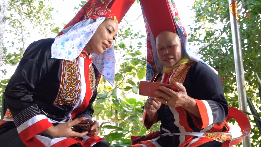 Chị Chìu Tài Múi (xã Yên Than) hướng dẫn người trong thôn dùng các ứng dụng của chuyển đổi số qua điện thoại thông minh.