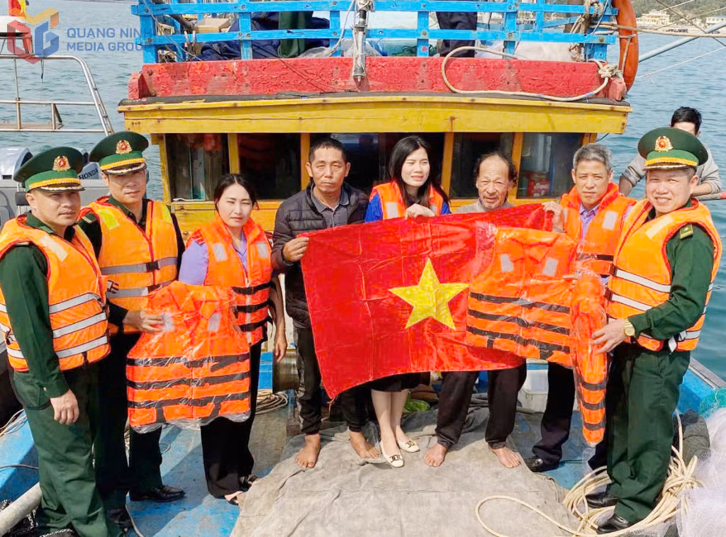 Cán bộ Đồn Biên phòng Thanh Lân phối hợp tặng cờ Tổ quốc cho các tàu cá trên vùng biển Cô Tô.