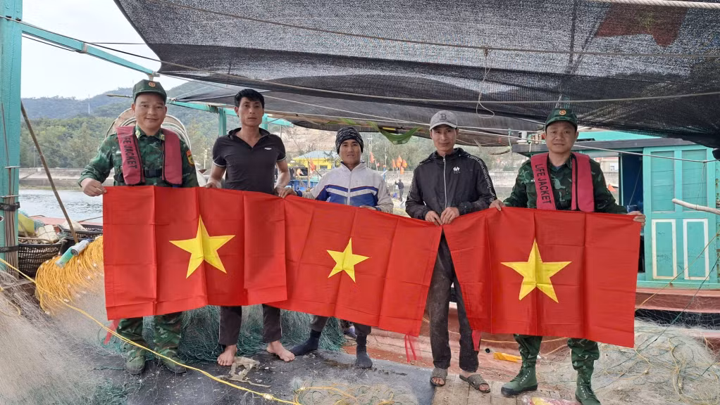 Cán bộ, chiến sĩ Đồn Biên phòng đảo Trần tặng cờ Tổ quốc cho ngư dân treo trên tàu cá, tạo không khí phấn khởi chào mừng cuộc bầu cử đại biểu Quốc hội khóa XVI và đại biểu Hội đồng nhân dân các cấp nhiệm kỳ 2026-2031.