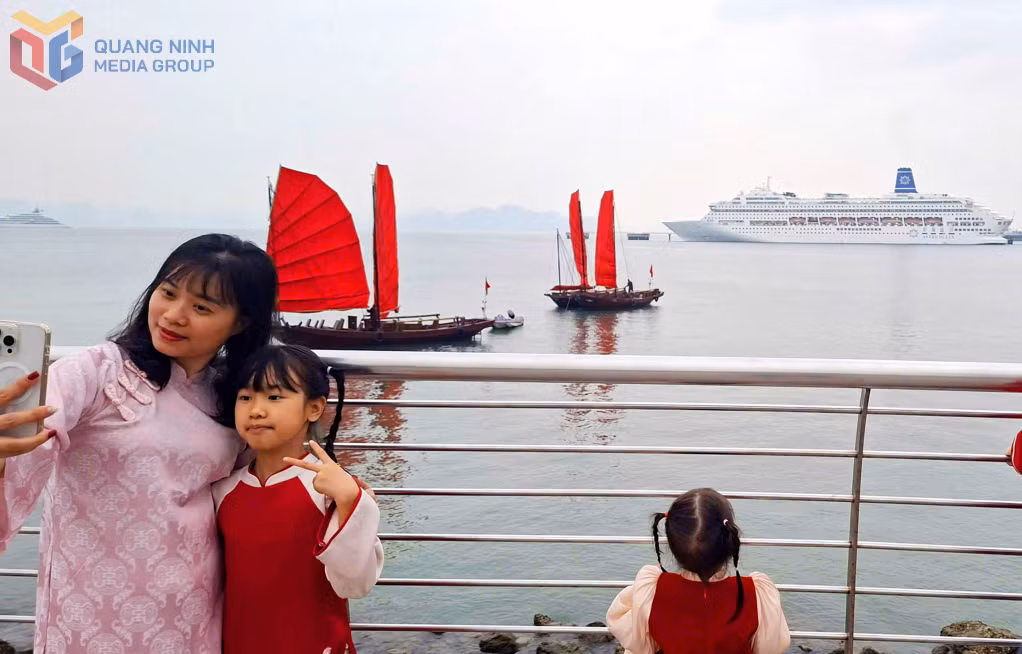 Chụp ảnh cùng thuyền ba vách buồm đỏ truyền thống ven bờ vịnh Hạ Long được nhiều du khách ưa thích.