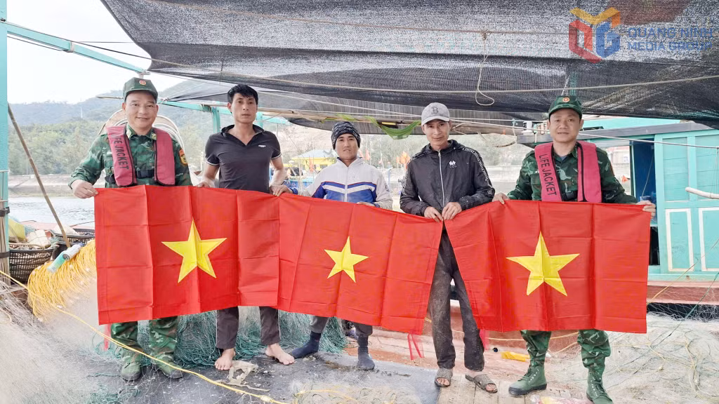 Đồn BP Đảo Trần tặng ảnh Bác Hồ và cờ Tổ quốc cho ngư dân.