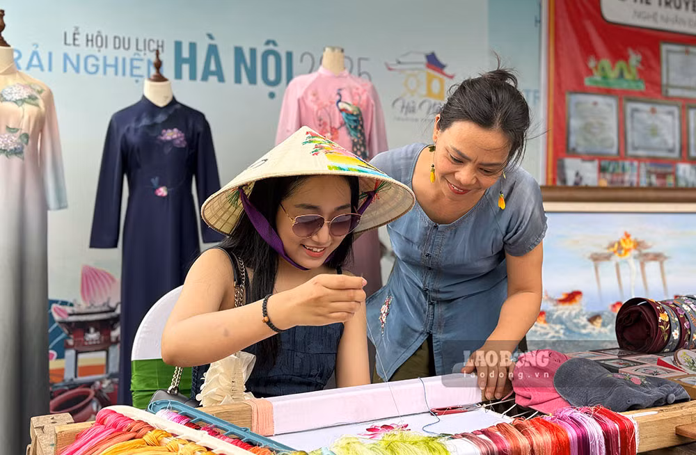 Khách tham quan trải nghiệm nghề thêu truyền thống tại Lễ hội Du lịch Hà Nội 2025. Ảnh: Ý Yên
