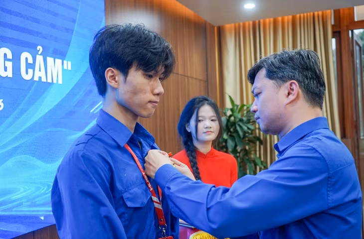 Bí thư Trung ương Đoàn, Chủ tịch Hội Sinh viên Việt Nam Nguyễn Minh Triết (bên phải) trao huy hiệu "Tuổi trẻ dũng cảm" cho sinh viên Nguyễn Lê Tú - Ảnh: VŨ TUẤN