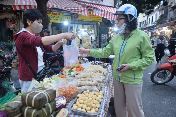 Người dân mua thực phẩm tại chợ Hàng Bè (Hà Nội) - Ảnh: PHÚC TÀI