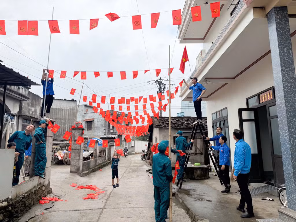 Thi công tuyến đường cờ Đảng - cờ Tổ quốc dọc tuyến đường vào nhà văn hóa thôn Co Nhan.