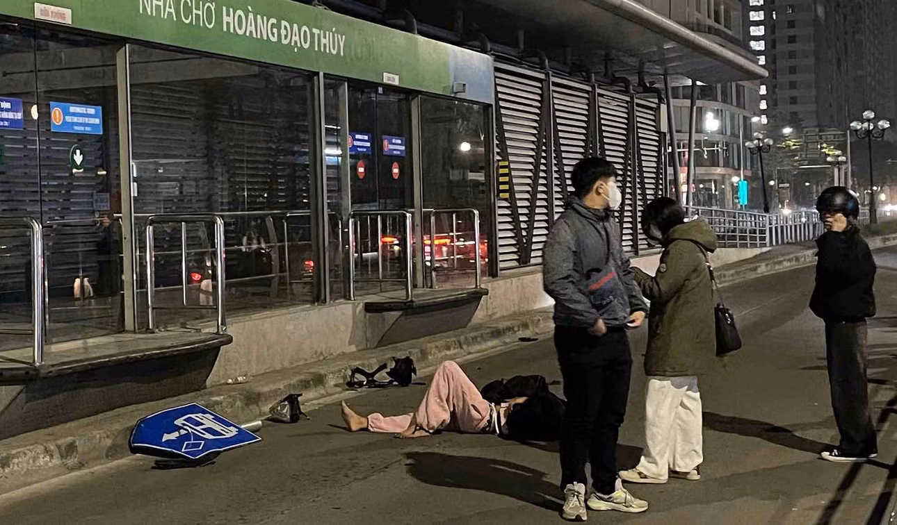 Nạn nhân nằm bất động trên mặt đường, được người dân và lực lượng chức năng hỗ trợ. Ảnh: Minh Vũ