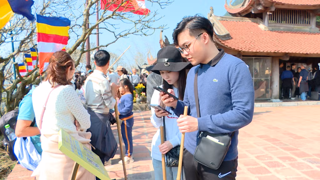 Khách du lịch quét mã QR để tìm hiểu về Khu di tích lịch sử và danh thắng Yên Tử.