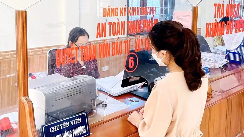 Công chức Bộ phận một cửa huyện Nghi Lộc (Nghệ An) giải quyết thủ tục hành chính cho người dân.