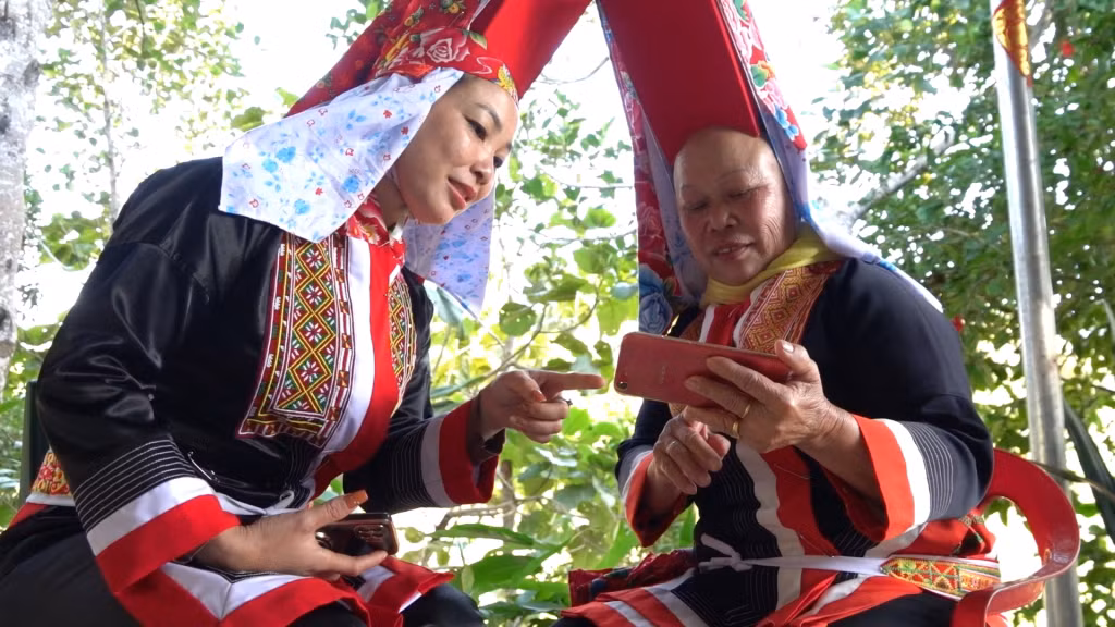 Chị Chìu Tài Múi, xã Yên Than, huyện Tiên Yên, (bên trái) hướng dẫn cho người cùng thôn bán hàng trên nền tảng số.