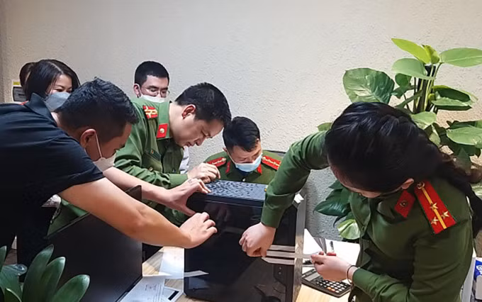 Cảnh sát khám xét trụ sở tập đoàn FLC, tối 29/3. Ảnh: CAND