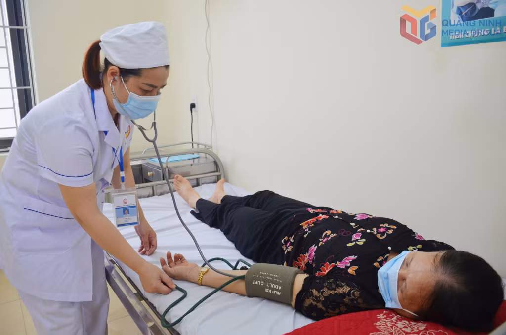 Nhân viên y tế tại Trạm Y tế phường Hiệp Hòa (Quảng Yên) đo huyết áp cho người dân đến khám bệnh định kỳ.