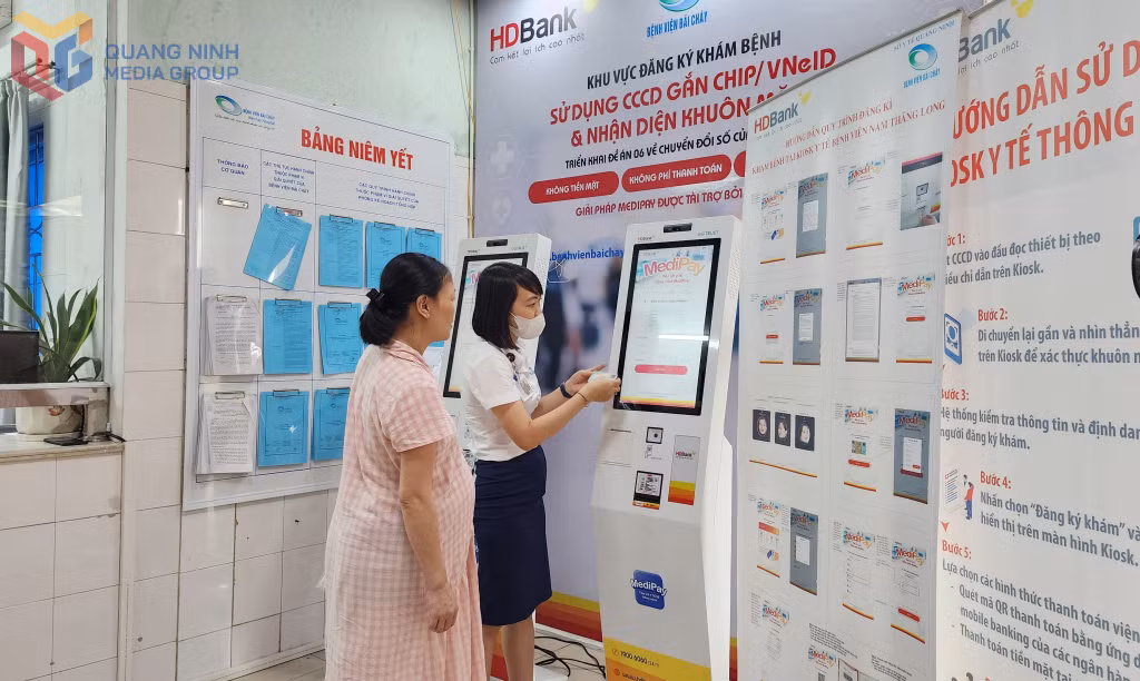 Nhân viên công tác xã hội Bệnh viện Bãi Cháy hướng dẫn người dân đăng ký khám bệnh trên hệ thống kiosk thông minh.