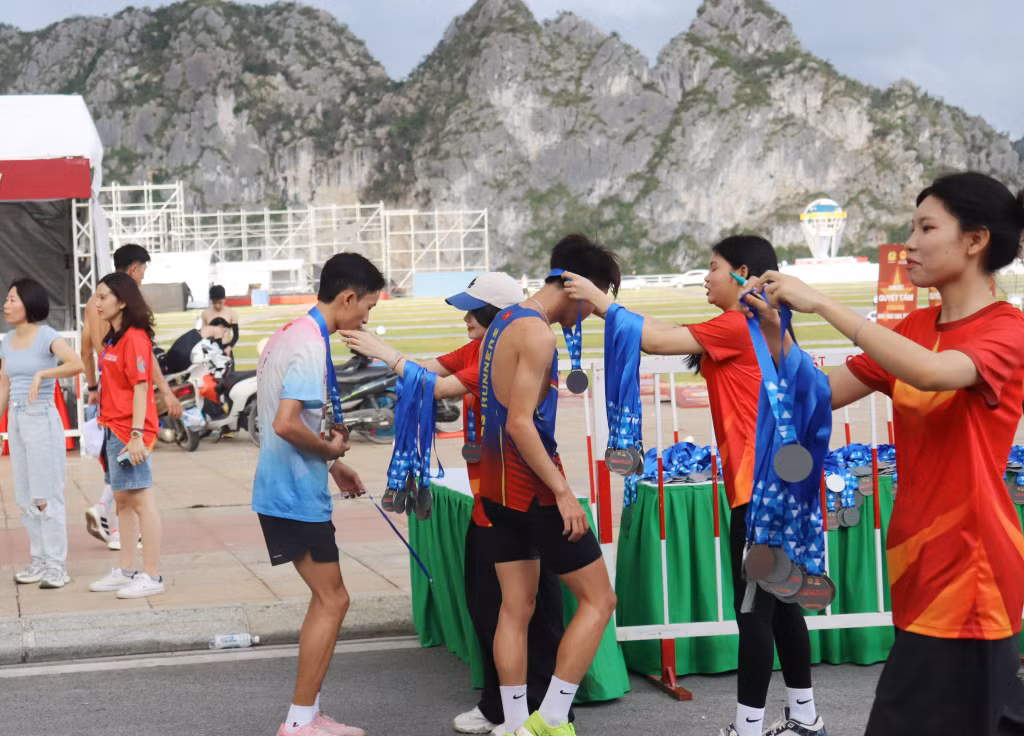 Nhận huy chương khi về đích.
