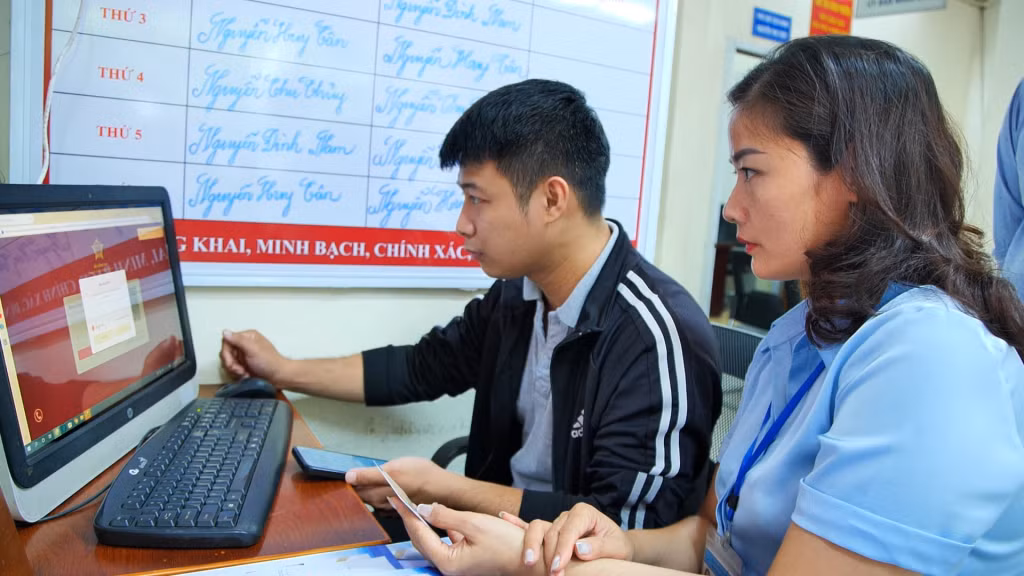 Cán bộ Tư pháp UBND phường Hà Lầm (TP Hạ Long) hỗ trợ người dân làm thủ tục liên thông “Đăng ký khai sinh - đăng ký thường trú - cấp thẻ bảo hiểm y tế cho trẻ em dưới 6 tuổi”.