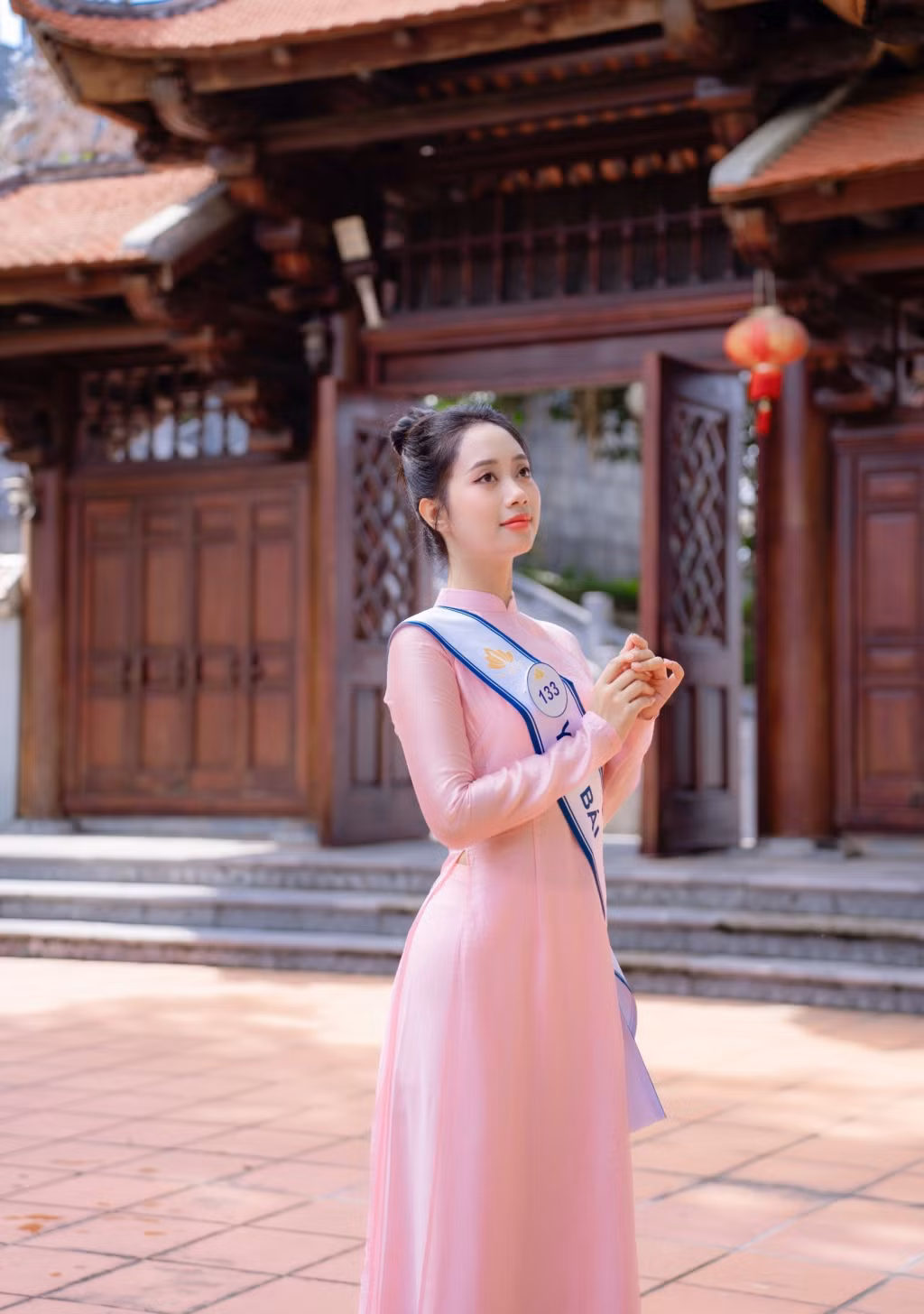 Thí sinh Nguyễn Mai Phương - SBD 133 đến từ tỉnh Yên Bái dịu dàng trong tà áo dài dưới cổng tam quan cổ kính của Đền Vũng Đục.