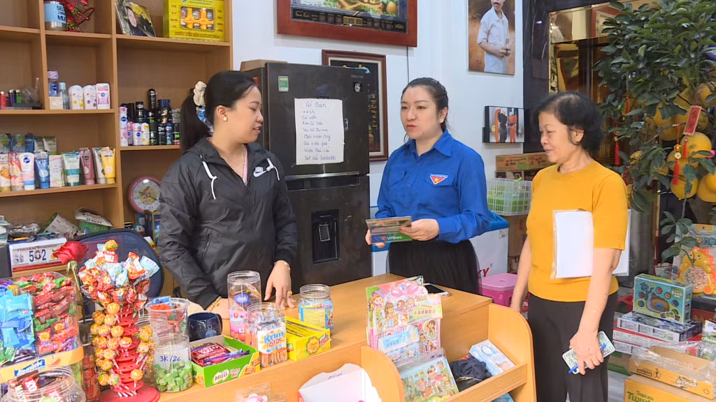 Đoàn viên, thanh niên phường Trần Hưng Đạo (TP Hạ Long) tuyên truyền đến chủ các cửa hàng và người dân lợi ích của việc thanh toán không dùng tiền mặt.
