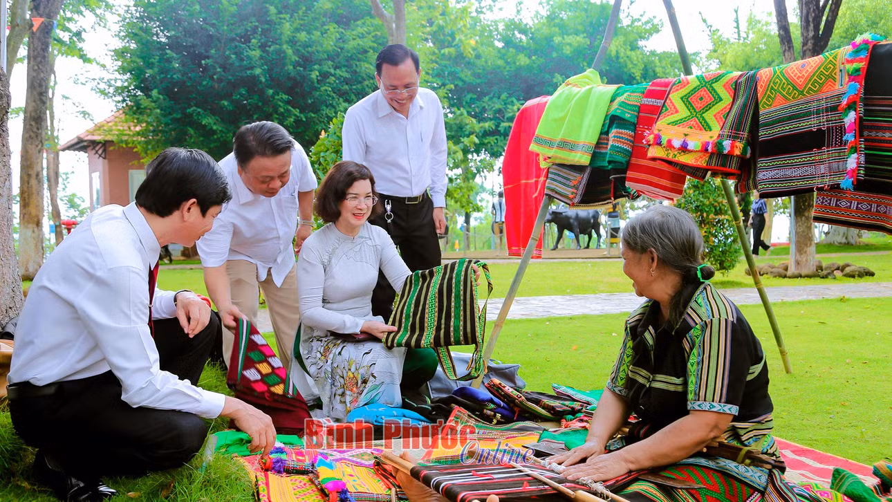 Lãnh đạo tỉnh và huyện Bù Đăng tham quan sản phẩm thổ cẩm của đồng bào M'nông ở Bình Phước - Ảnh: Trương Hiện