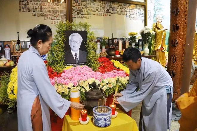Cộng đồng người Việt tại Lào thắp hương tưởng nhớ Tổng Bí thư Nguyễn Phú Trọng. (Ảnh: Đỗ Bá Thành/TTXVN)