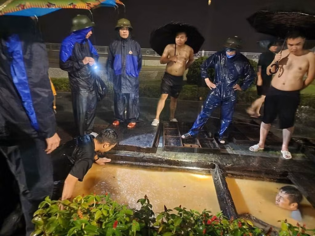 Cán bộ phường Hồng Hà và các lực lượng chức năng của TP Hạ Long khơi thông dòng chảy trong đêm 29/7.