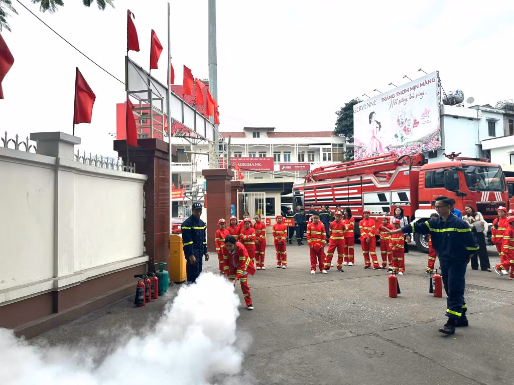Các em thiếu nhi được hướng dẫn dập lửa bằng bình cứu hỏa.