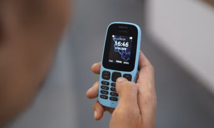 Một người sử dụng điện thoại "cục gạch" trước ngày tắt sóng 2G, tháng 10/2024. Ảnh: Lưu Quý