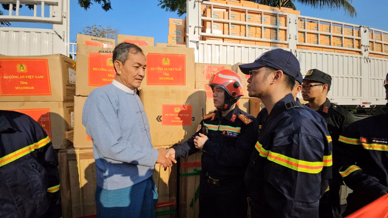 Đại tá Nguyễn Minh Khương - Trưởng đoàn công tác Bộ Công an Việt Nam trao quà cứu trợ cho nước bạn. Ảnh: Lê Hoàng