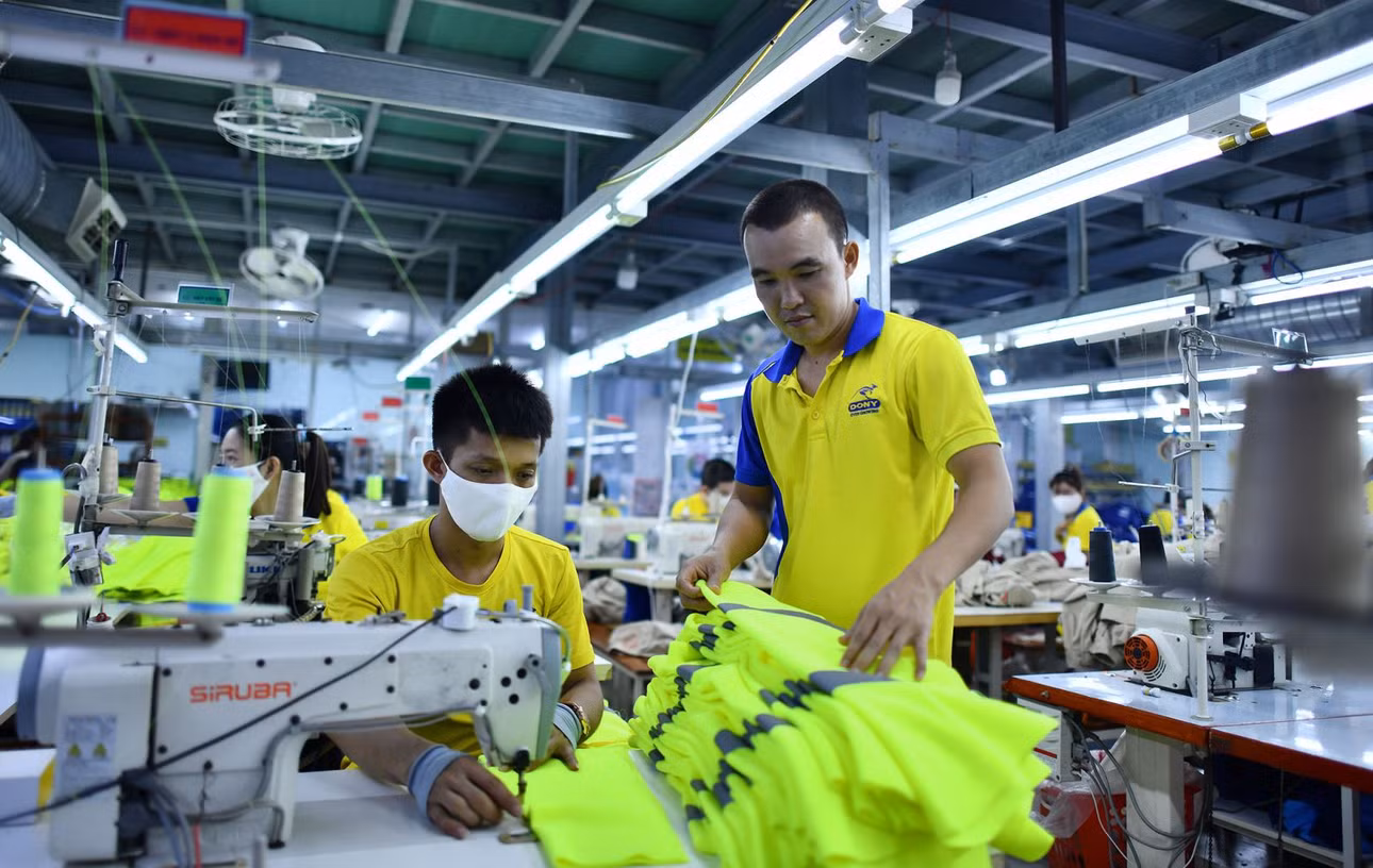 Ông Phạm Quang Anh, Tổng Giám đốc Công ty cổ phần Quốc tế Dony (bìa phải) kiểm tra các mẫu áo của công ty phục vụ thị trường xuất khẩu.