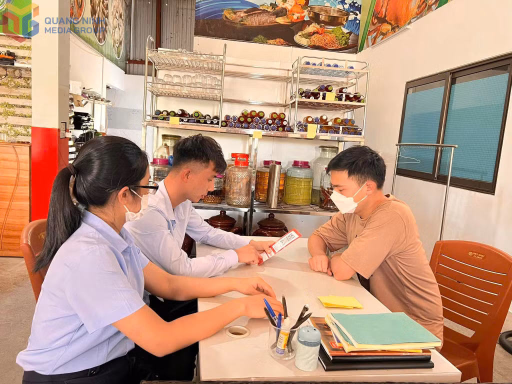 Cán bộ xã Tiền An phối hợp cùng ngân hàng tuyên truyền, hỗ trợ tiểu thương trên địa bàn tạo mã QR thanh toán không dùng tiền mặt.