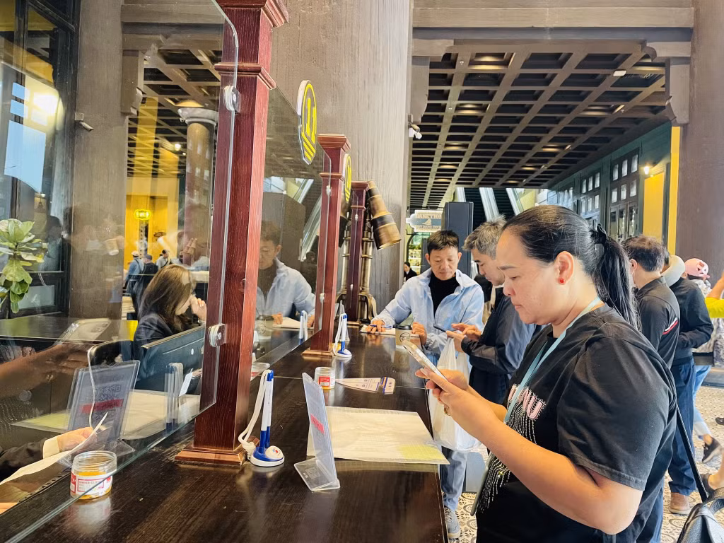 Khách du lịch thanh toán không dùng tiền mặt khi tham quan vịnh Hạ Long.